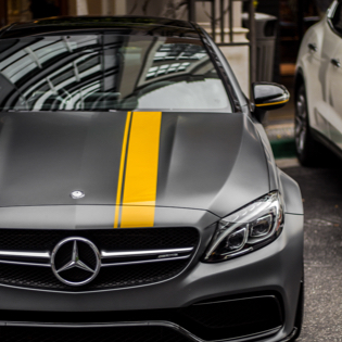 view of fron of a grey mercedes with a yellow stripe in the middle